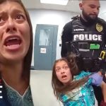 Police officer detaining a woman in distress.