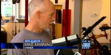 Man interviewed in fitness studio setting.