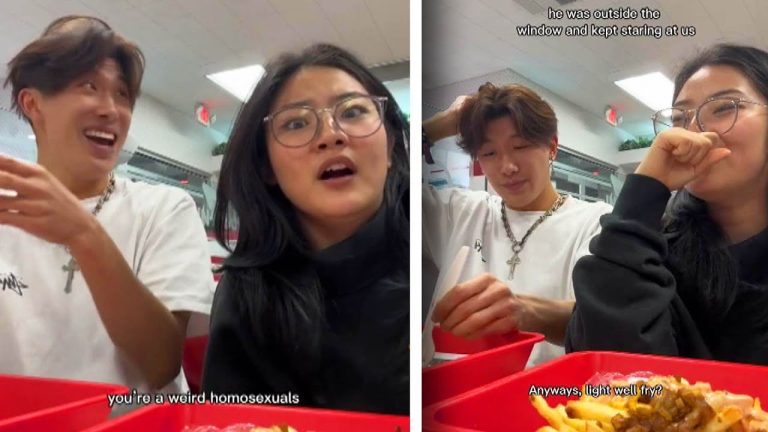 Two friends eating at a restaurant, laughing together.