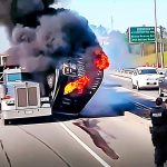 Truck fire on highway with police officers nearby