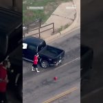 Man in red beside black pickup truck, Oklahoma City.