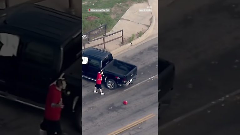 Man in red beside black pickup truck, Oklahoma City.