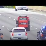 Tractor leading police on highway chase with traffic.