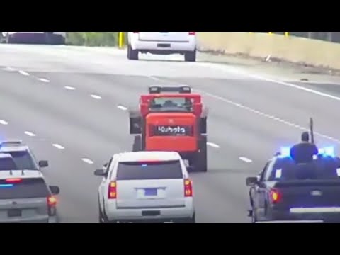 Tractor leading police on highway chase with traffic.