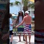 Three men talking on boardwalk, palm trees background.