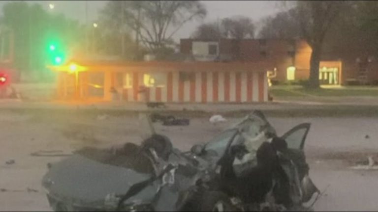 Car crash scene with traffic lights and building.