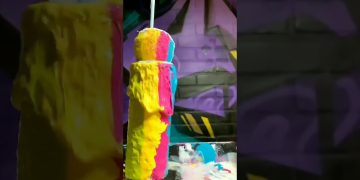 Colorful paint dripping on sponge cylinder.