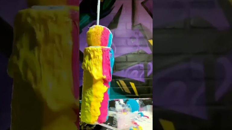 Colorful paint dripping on sponge cylinder.