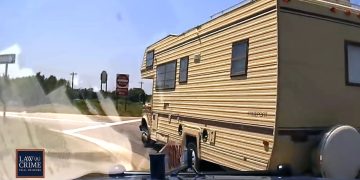 RV on highway intersection captured by dashcam.