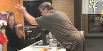 Customer angrily confronts fast-food worker at counter.