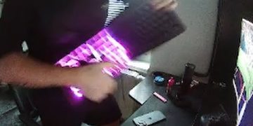 Person playing keyboard like a guitar with lights