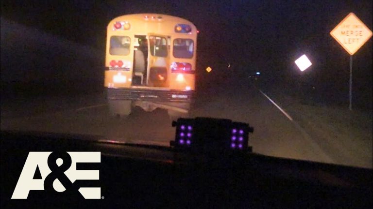 Police chase school bus at night on highway.