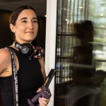 Woman with headphones holding a water bottle.