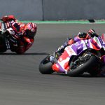 Motorcycle racers leaning in high-speed corner.