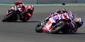 Motorcycle racers leaning in high-speed corner.