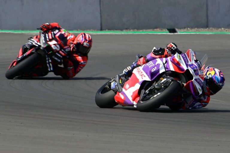 Motorcycle racers leaning in high-speed corner.