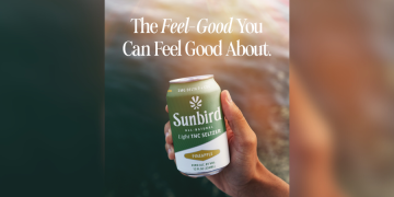 Hand holding Sunbird Pineapple THC Seltzer can.