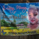 Memorial banner with two children nearby.