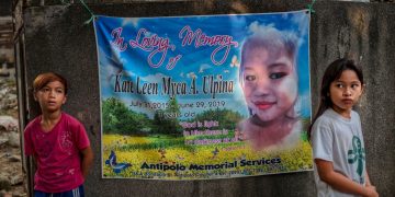 Memorial banner with two children nearby.