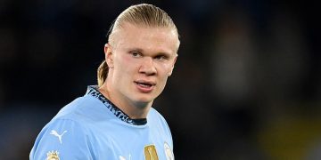 Soccer player in blue jersey on the field.