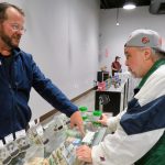 Man buying cannabis products at dispensary counter.