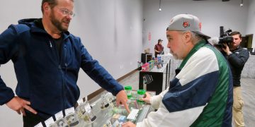 Man buying cannabis products at dispensary counter.