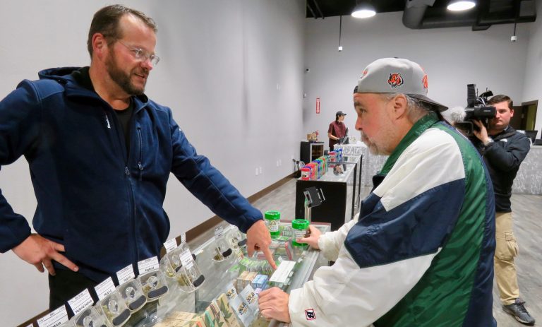 Man buying cannabis products at dispensary counter.