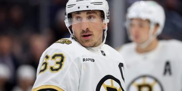 Hockey player on ice in Boston Bruins jersey.