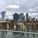 Downtown Austin skyline over river with bridge.