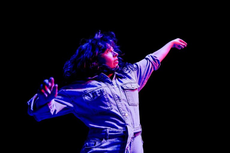 Person dancing under colorful stage lights.