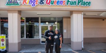 Entrance of Kings & Queens Fun Place with people.