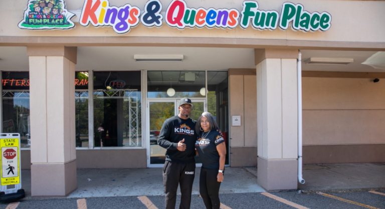 Entrance of Kings & Queens Fun Place with people.