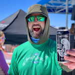 Man enjoying outdoor event with SweetWater beer can.