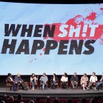 Panel discussion in front of 'When Sh!t Happens' screen.