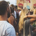 People enjoying outdoor summer festival with drinks.