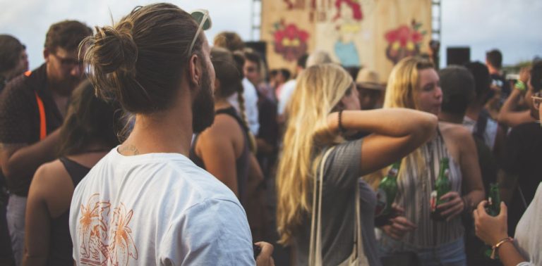 People enjoying outdoor summer festival with drinks.