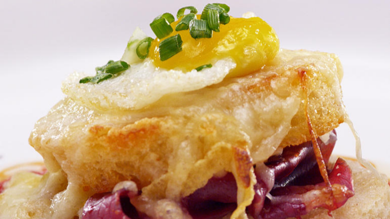 Open-faced sandwich with egg and cheese topping.