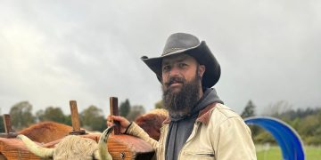 Man in cowboy hat, overcast sky background