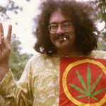 Person holding peace sign with cannabis leaf shirt