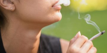 Person smoking outdoors in daytime