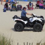 Police officer on ATV at busy beach