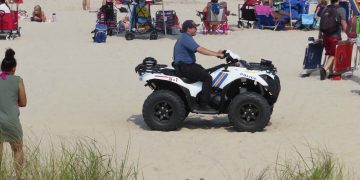 Police officer on ATV at busy beach