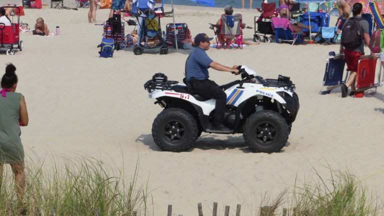 Police officer on ATV at busy beach