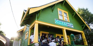 GreenHop store exterior with group of people gathering