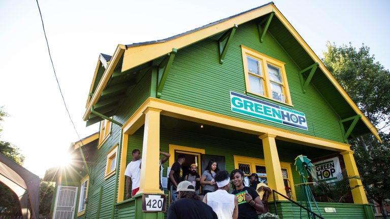 GreenHop store exterior with group of people gathering