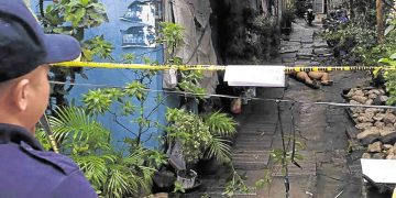 Crime scene with police caution tape and alleyway.