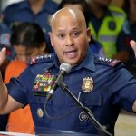 Police officer speaking at a podium.