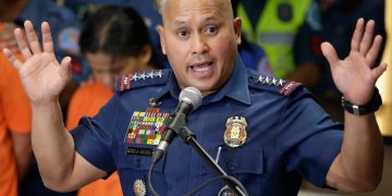 Police officer speaking at a podium.