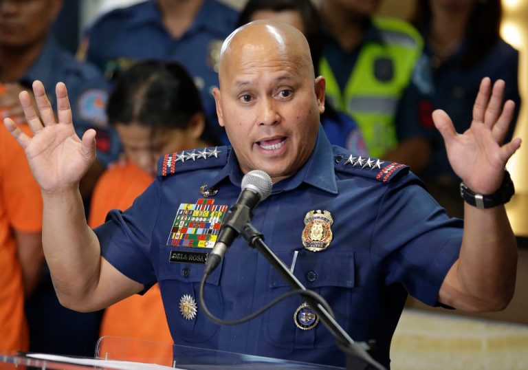 Police officer speaking at a podium.