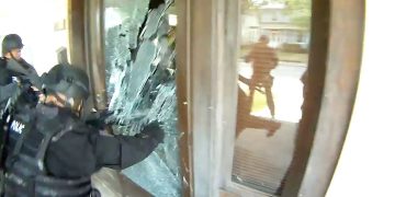 Police breaking glass door during operation